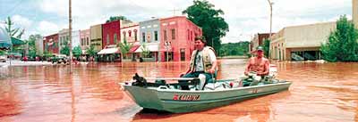 men in boat in flooded downtown